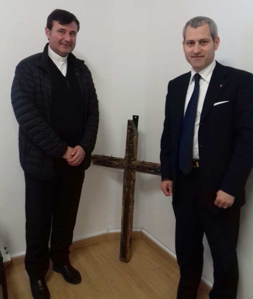 Don Alberto Fossati e il Presidente Fabrizio Verduchi con al centro un antico Crocifisso recuperato da una chiesa crollata a causa del sisma.